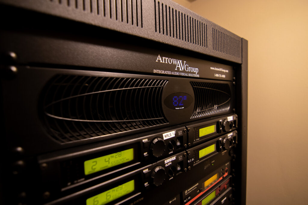 Close up of the main rack of the worship system. Wireless microphones are seen at the top of the rack.